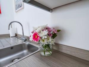 a vase filled with flowers sitting next to a sink at Glenholme Apartment 6 in Redcar