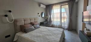 a bedroom with a large bed and a window at Ika Delux in Burgas