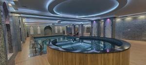فندق النبراس AlNebras Hotel的一座大楼内带热水浴池的游泳池