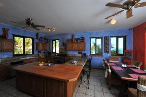 a kitchen with blue walls and a large island in the middle at Villa Marlin by Cabo Villas in La Paz