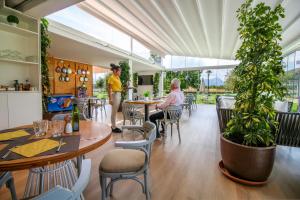 a couple sitting at a table in a restaurant at Duvabitat Apartments in Port de Pollensa