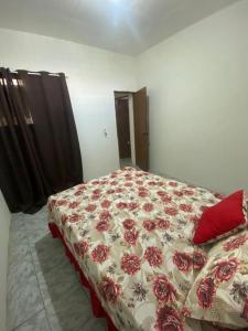 a bedroom with a bed with a red and white blanket at apartamento completo simples 5 minutos do moda center in Santa Cruz do Capibaribe