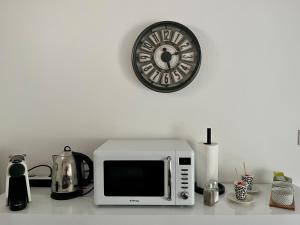 a microwave on a counter with a clock on the wall at Détente aux beaumonts in Chouzy-sur-Cisse +2 photos
