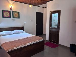 een slaapkamer met een groot bed en een deur bij Wiki Villa in Bentota