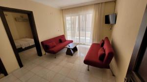 a living room with two red chairs and a mirror at Akın Turunç Pansiyon in Marmaris