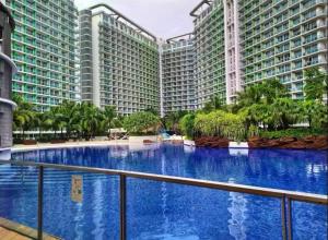 a large swimming pool in the middle of two large buildings at Man-made beach waves 19 minutes from NAIA in Manila