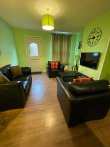 a living room with couches and a flat screen tv at Cathedral View in Norwich