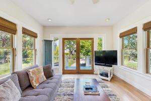 a living room with a couch and a flat screen tv at Starlite Vineyard Escape in Geyserville