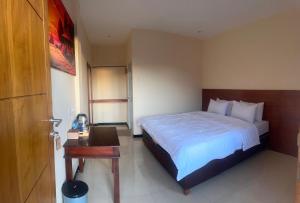 een slaapkamer met een groot bed en een tafel bij PESONA BROMO Homestay in Probolinggo +10 foto's