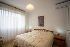 a bedroom with a bed and a large window at Casa Elena - Vista Mare e Parcheggio in San Vincenzo