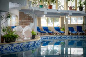 a swimming pool with blue chairs in a building at Snezhanka Hotel Pamporovo- All inclusive & Swimming pool in Pamporovo