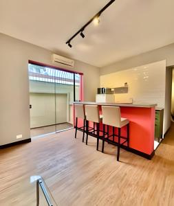 an open kitchen with a red counter and chairs at KiTNETcompleta ótima localização in Curitiba +12 photos
