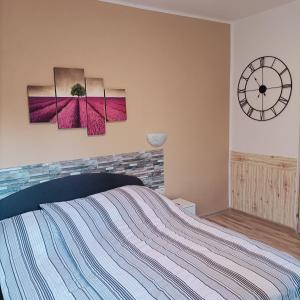 a bedroom with a bed and a clock on the wall at Ubytovanie Pepo in Štúrovo