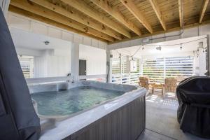 a large soaking tub in a room with a table at Rum-DCA 600 ft to Beach with Hot Tub and Backyard in Nags Head