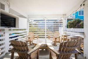 a patio with chairs and a table and a tv at Rum-DCA 600 ft to Beach with Hot Tub and Backyard in Nags Head