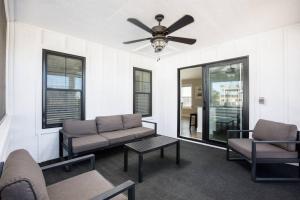 a living room with a couch and a ceiling fan at Rum-DCA 600 ft to Beach with Hot Tub and Backyard in Nags Head