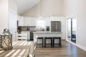 a kitchen with white cabinets and a kitchen island with chairs at Rum-DCA 600 ft to Beach with Hot Tub and Backyard in Nags Head +27 photos