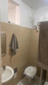a bathroom with a sink and a toilet and a mirror at Apartamento no centro in Jequié