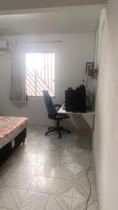 a room with a desk and a chair and a window at Apartamento no centro in Jequié +1 photo