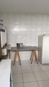 a kitchen with a table and a refrigerator at Apartamento no centro in Jequié