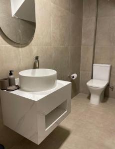 a bathroom with a white sink and a toilet at Villa on the sands in Ureki