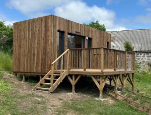a wooden house sitting on a wooden deck at Lou Mazet Séjour en Aubrac in Saint-Laurent-de-Muret