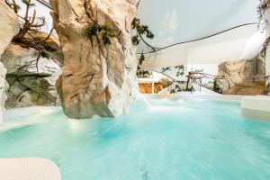 a pool of water with a rock wall at Almhof Hotel Call in San Vigilio Di Marebbe