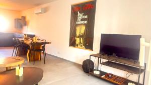 a living room with a flat screen tv and a table at Spacieux T3 Emplacement idéal in Calvi