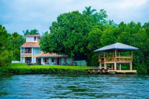 a house with a gazebo next to a body of water at Okvin River Villa in Bentota