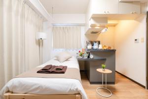 a small bedroom with a bed and a table at Sakura Serenity House Komagome in Tokyo +200 photos