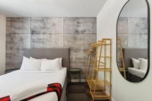 a bedroom with a bed and a mirror and a ladder at Auberge Manitonga in Mont-Tremblant