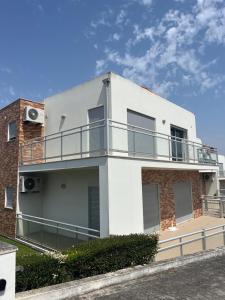 a white building with a balcony on the side of it at G at Bela Baia Salir in Salir de Porto