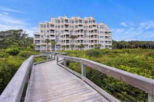 un paseo marítimo de madera que conduce a un gran edificio en WS5127: 5127 Windswept, en Kiawah Island