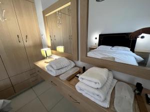 a bathroom with a mirror and a bed with towels at 4 seasons apartment 102 eco in Thiva