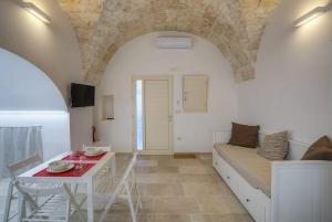 a living room with a couch and a table at Casa Terra Antica Timeless Apulian Charm in Ceglie Messapica