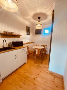 een keuken en eetkamer met een tafel bij Menasagi Sit & Dream Cottage 2 in Menasag-Ujfalu