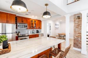 an open kitchen with wooden cabinets and a large wooden table at The Newport Lofts - 410 Thames Street in Newport