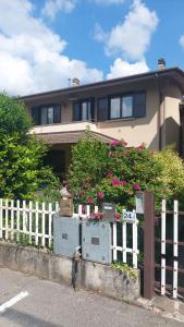 ein Haus mit einem weißen Zaun und Blumen davor in der Unterkunft Delizioso appartamento sul lago - Casa Marina in Spinone Al Lago