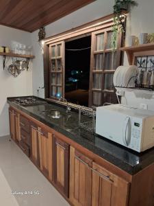a kitchen with a sink and a microwave on a counter at 01 Lindo apartamento na praia com piscina in São Sebastião