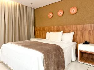 ein Hotelzimmer mit 2 Betten und 2 Uhren an der Wand in der Unterkunft STAY Vivence Suítes in Palmas