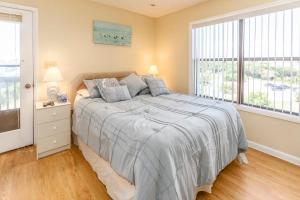 una camera da letto con un letto e due finestre di In Duck with Community Pool & Beach Access a Duck