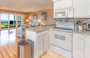 una cucina con elettrodomestici bianchi e un soggiorno di In Duck with Community Pool & Beach Access a Duck