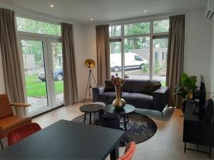 a living room with a couch and a table at Boshuisje met hottub in Haarle +2 photos