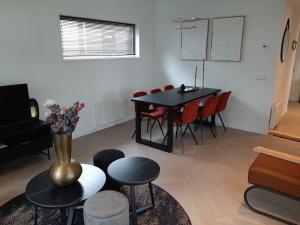 a living room with a black table and red chairs at Boshuisje met hottub in Haarle