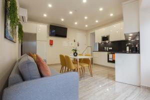 a living room and kitchen with a couch and a table at Solar Mendonça Boutique Hotel in Faro