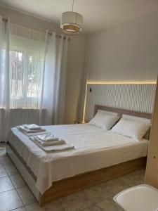 sypialnia z dużym białym łóżkiem z ręcznikami w obiekcie Sozopoli Hawaii Beach House w mieście Sozopoli