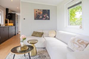 a living room with a white couch and a table at Chalet Chique in Oldeberkoop