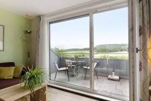a room with a balcony with a table and chairs at Landpension Wachtkopf in Vaihingen an der Enz