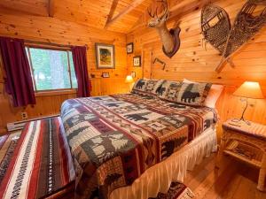 une chambre avec un lit dans une cabane en rondins dans l'établissement Gibbs Cottage, à Eagle Bay