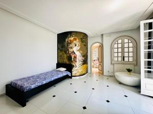 a bedroom with a painting on the wall and a bed and a tub at Global Immo 8010 Montclar in Roses +32 photos